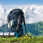 Tourist backpack and sleeping pad on a background of mountains