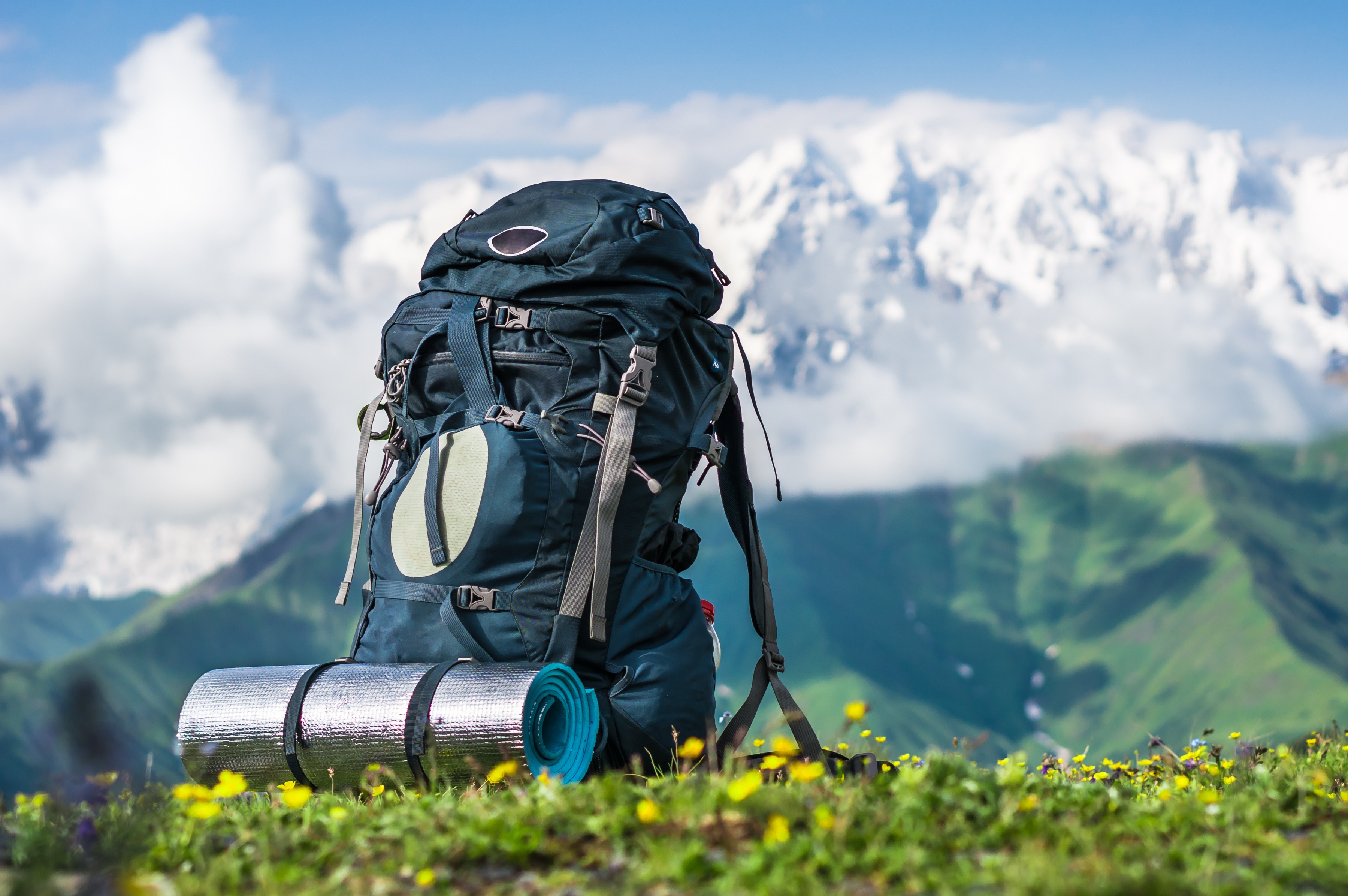 Tourist backpack and sleeping pad on a background of mountains